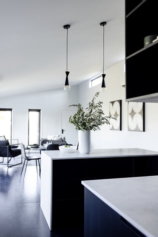 large white living room and black kitchen